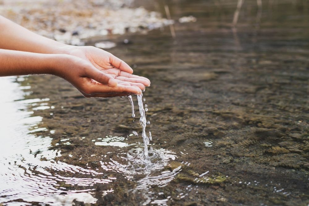 scooping water from fresh spring with cupped hands